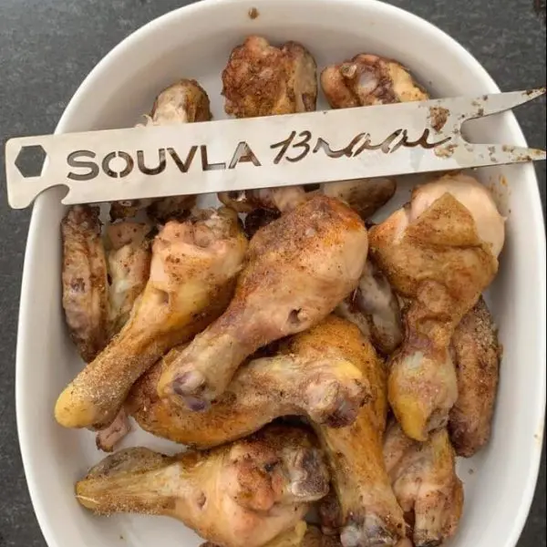 Chicken Souvla in pyrex dish with a souvla braai fork made on a souvla braai