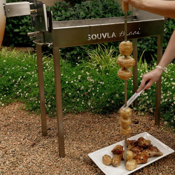 Souvla Braai souvla fork being used to take potatoes off a large skewer